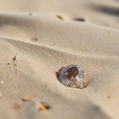 Sterling Silver Garnet Ring in sand at the beach